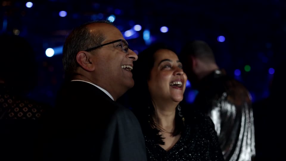 Two guests laughing together beside the Viewso capture setup at the DaVita celebration