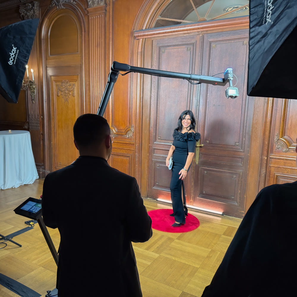 A formally dressed guest receiving direction from a Viewso operator beside the Glambot robotic camera