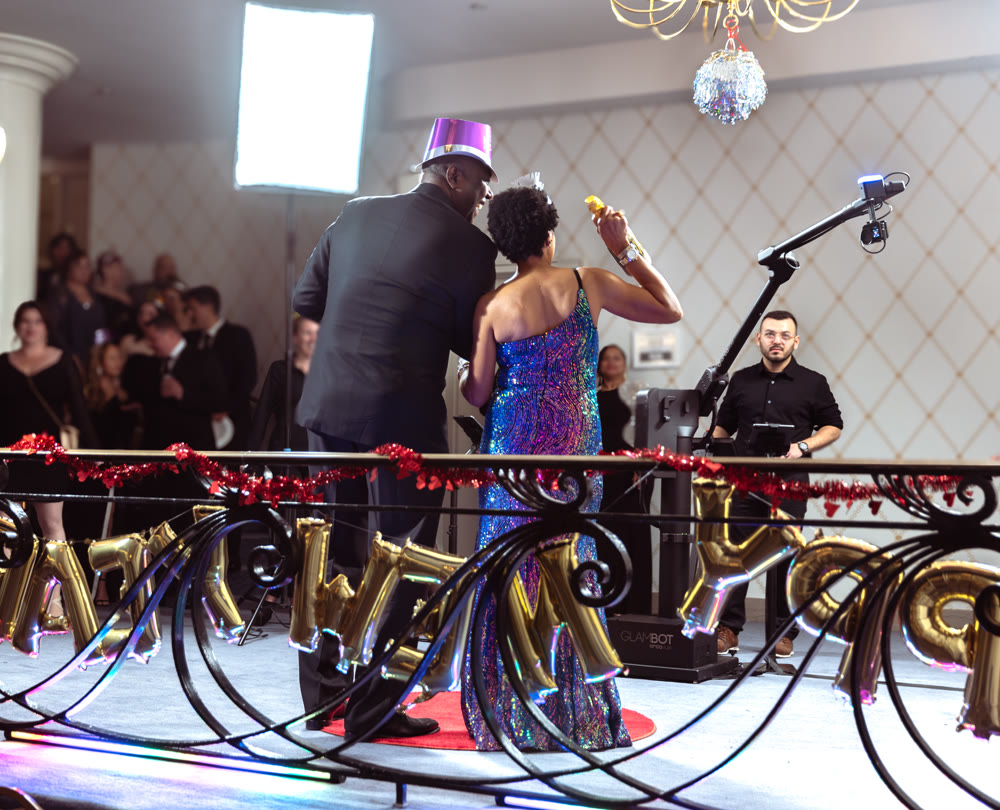 Guests in formalwear being directed by a Viewso operator while the robotic Glambot camera captures them