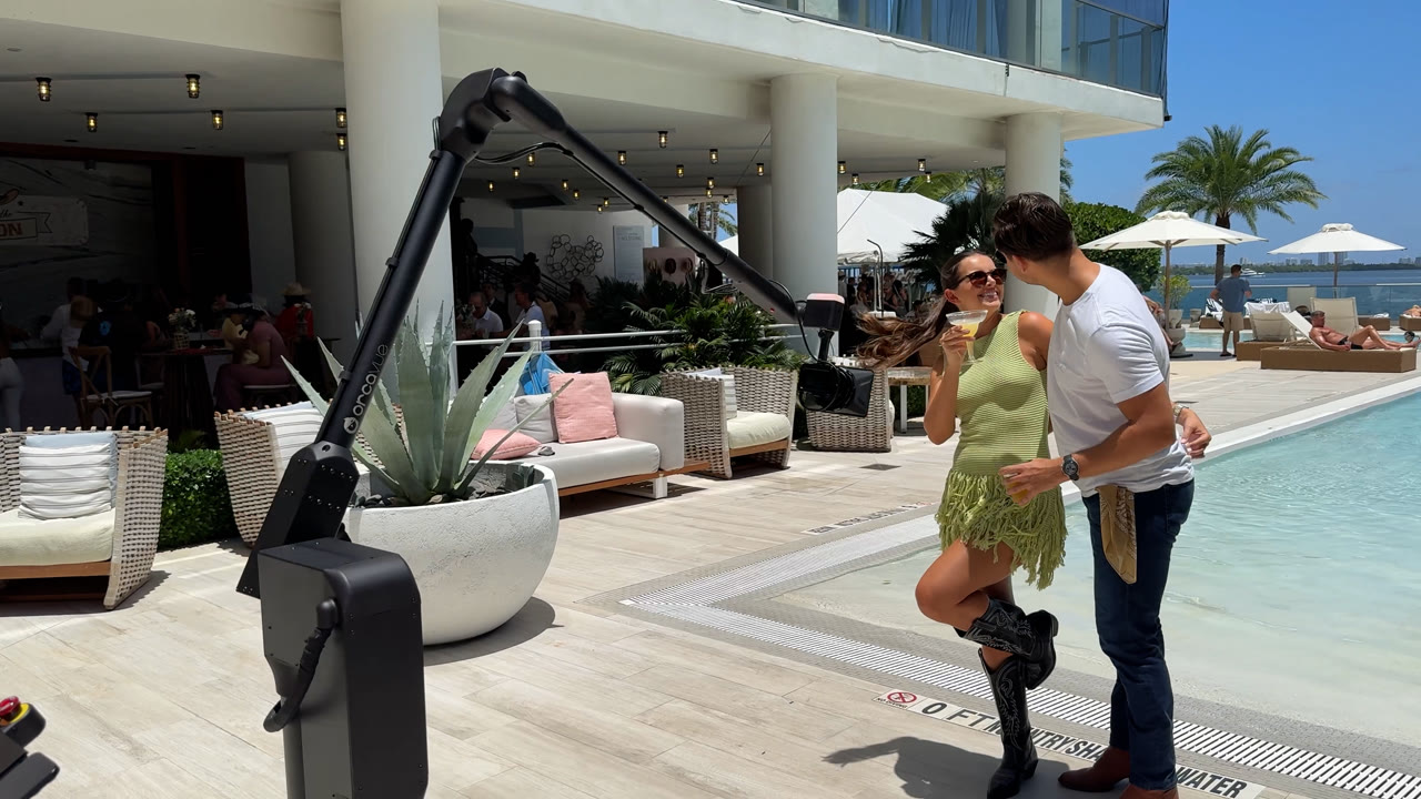 A couple posing beside a pool as the Viewso robotic Glambot camera captures them